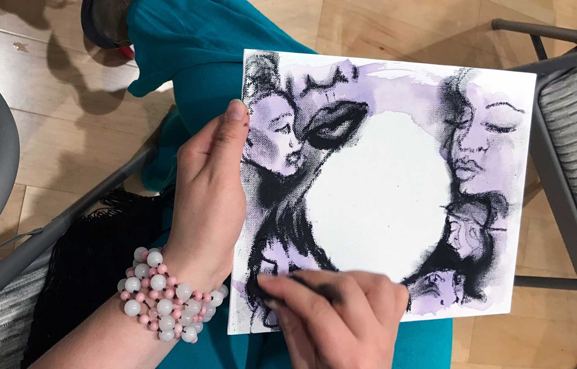 Woman's hands shown drawing picture as therapy.