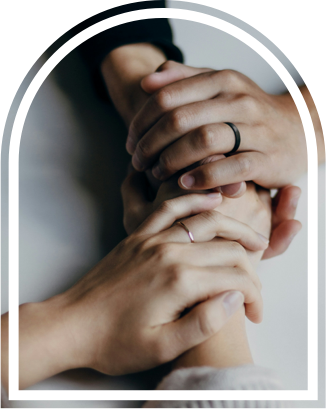 Close-up of two people holding hands in show of support.